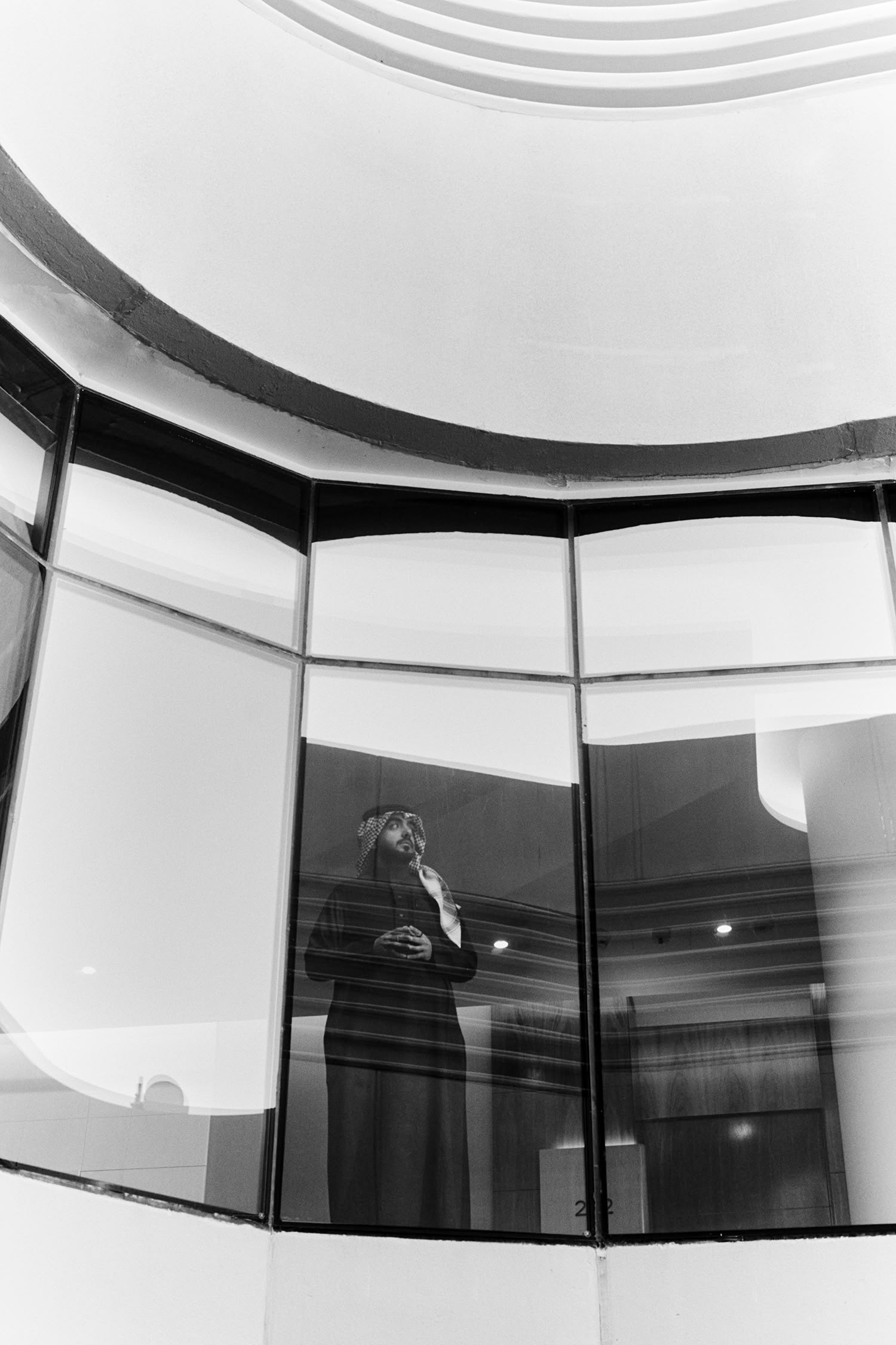 Black and white image of executive behind glass representing Arabian Business data-driven marketing and lead generation services.