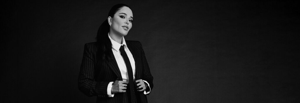 Professional businesswoman in tailored suit featured in Arabian Business leadership campaign.