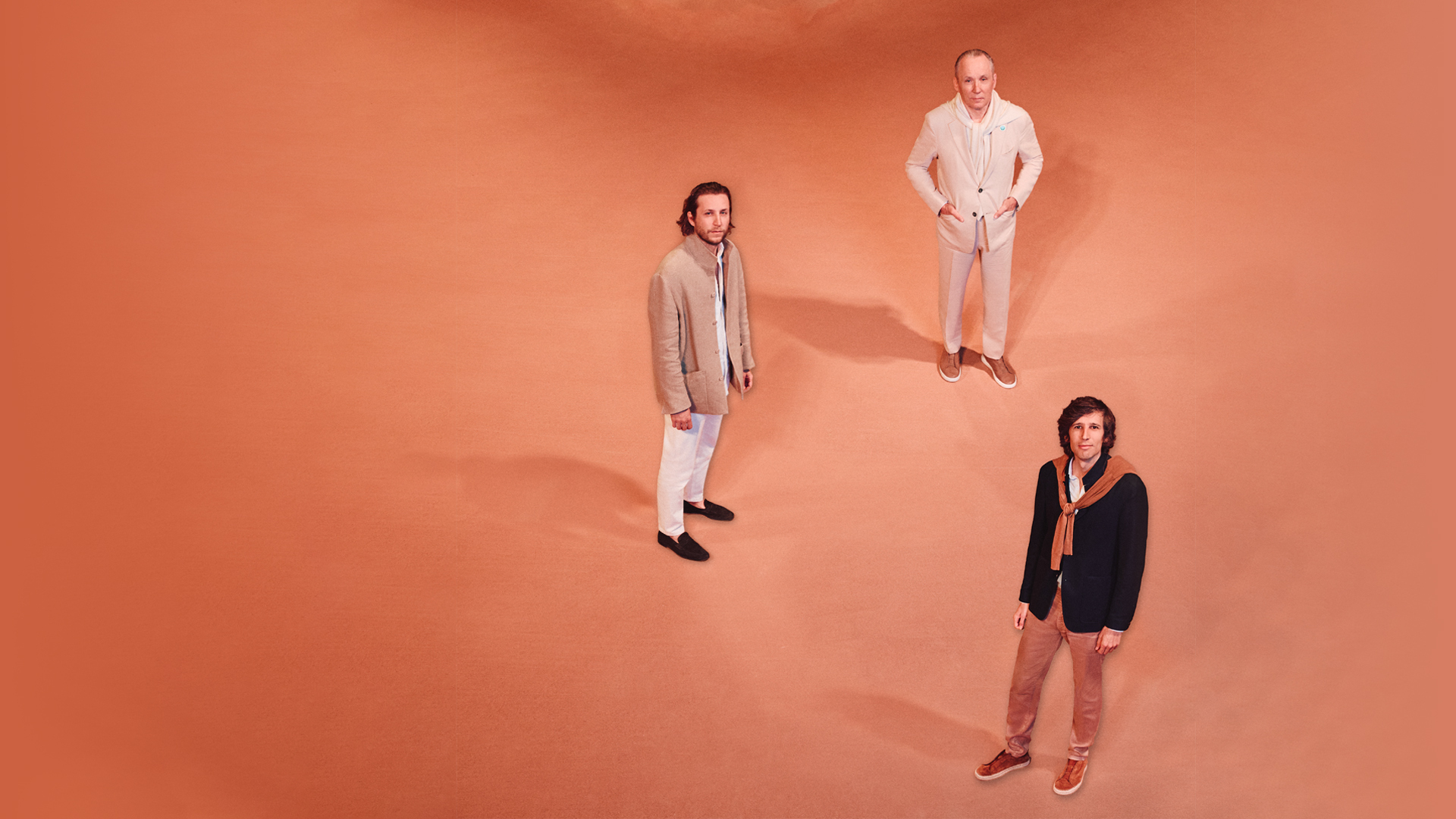 Three business executives standing in a studio setting featured in Arabian Business magazine.