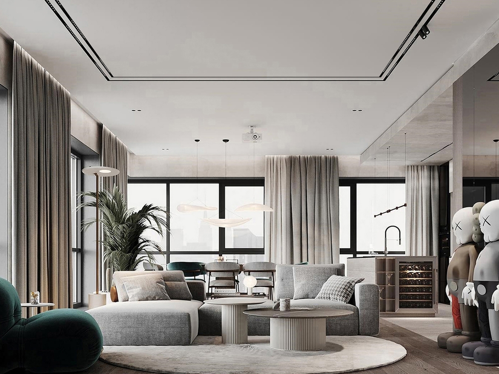 A modern open-plan living room featuring neutral-toned sofas, a round coffee table, large floor-to-ceiling windows with sheer curtains, indoor plants, and soft natural daylight filling the space.