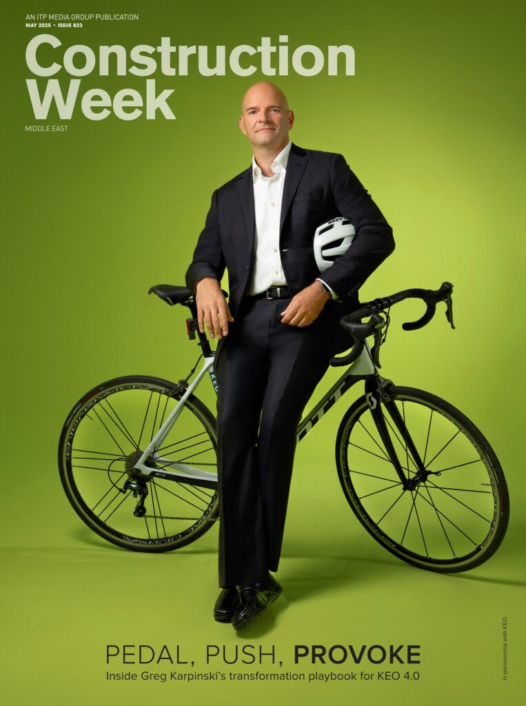 Construction Week magazine cover featuring an executive standing with a bicycle against a green background.