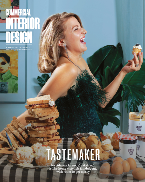 A magazine cover featuring a woman smiling while holding stacked food items in a vibrant studio setting.