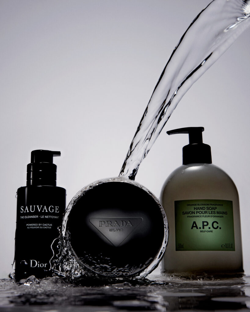 Premium men’s grooming products including fragrance and skincare displayed with water splash representing Esquire Middle East grooming culture.
