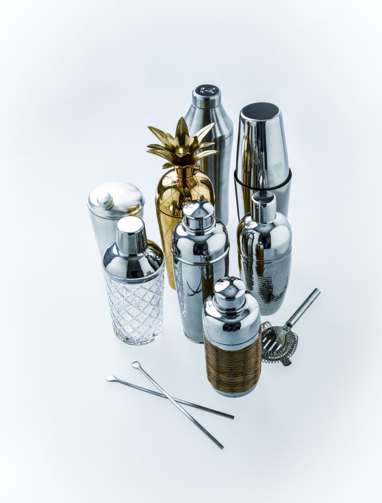 Premium cocktail tools and bar accessories arranged in a minimalist flat lay representing Esquire Middle East men’s lifestyle and entertaining culture.