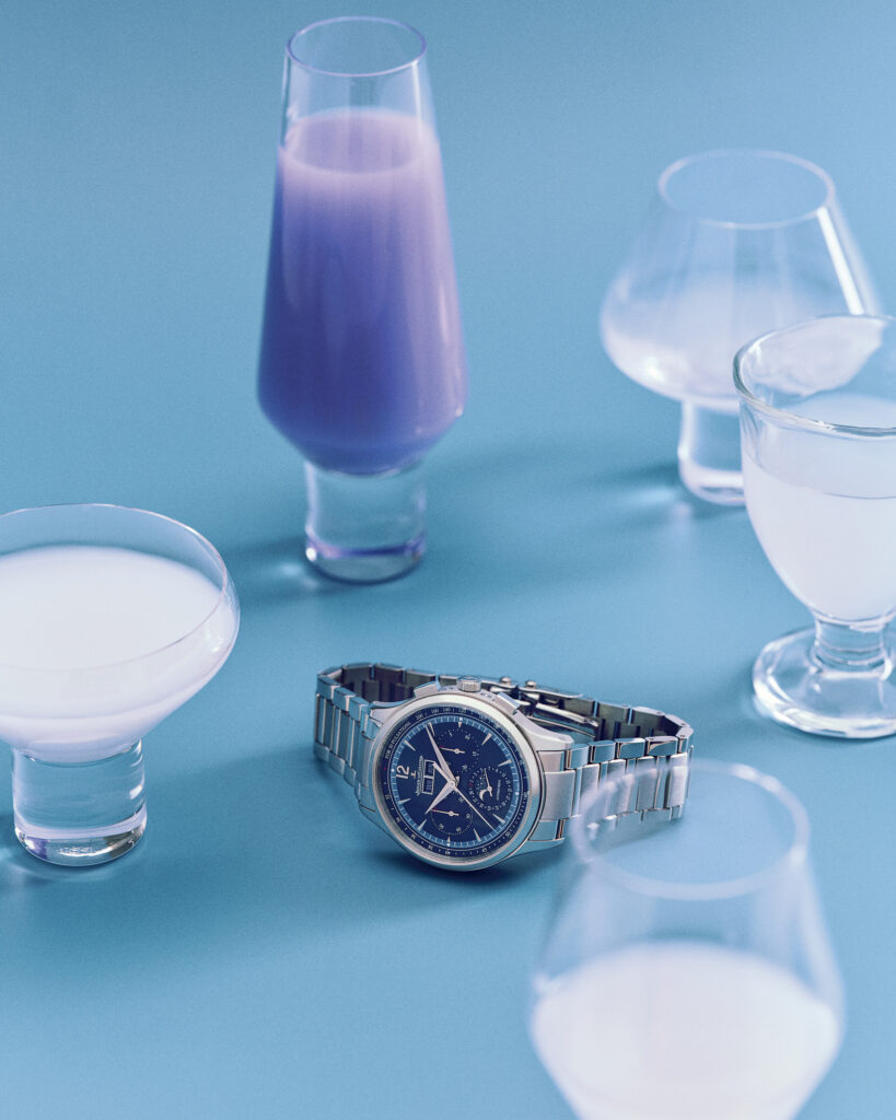 Luxury wristwatch placed beside modern cocktails in a minimalist setting representing Esquire Middle East men’s luxury lifestyle.