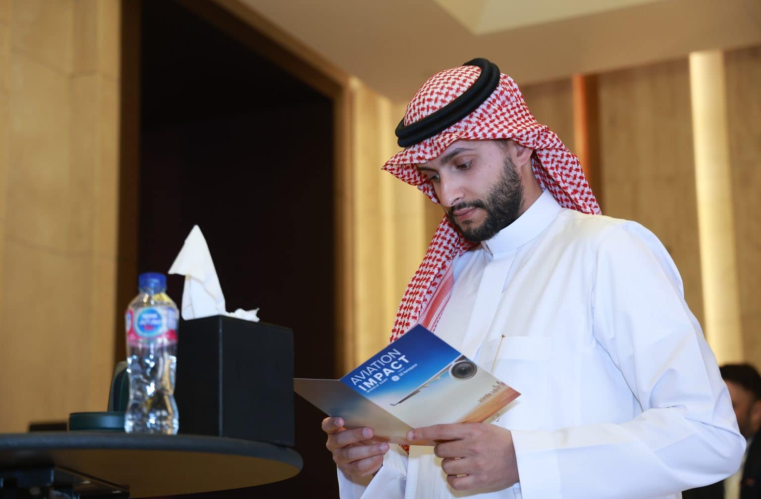 Middle East aviation professional reviewing event material at Aviation Business Middle East industry forum.
