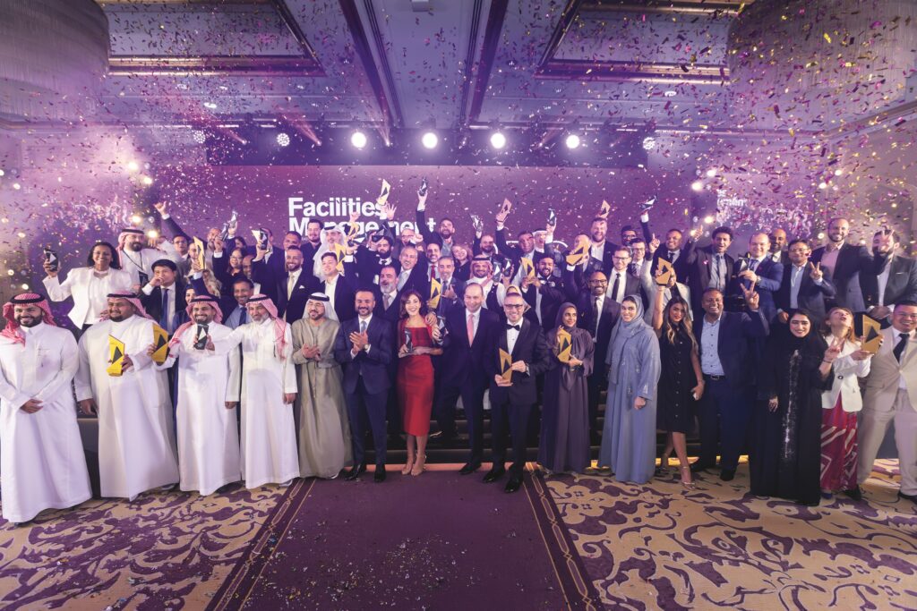 Large group of facilities management professionals celebrating on stage at the Facilities Management Middle East awards event.