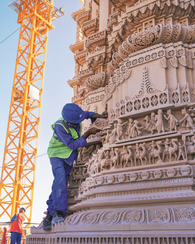Technician performing detailed maintenance work on a building facade representing Facilities Management Middle East infrastructure and facilities services.